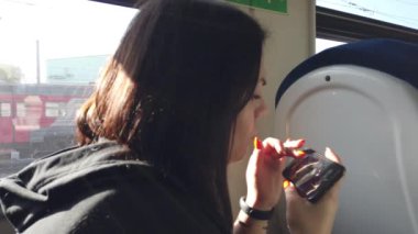 Trendeki kız ve bir akıllı telefon. Seyahat taşımacılığı demiryolu konsepti. Pencerede trende kız pencerede tren vagonundaki kıza karşılık gelir..