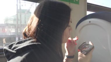 Trendeki kız ve bir akıllı telefon. Seyahat taşımacılığı demiryolu konsepti. Pencerede trende kız pencerede tren vagonundaki kıza karşılık gelir..