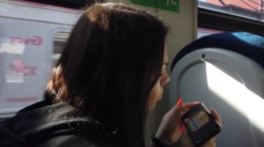 Trendeki kız ve bir akıllı telefon. Seyahat taşımacılığı demiryolu konsepti. Pencerede trende kız pencerede tren vagonundaki kıza karşılık gelir..