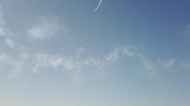 Gökyüzündeki bir uçak akrobasi figürlerini gösteriyor.