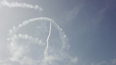Gökyüzündeki bir uçak akrobasi figürlerini gösteriyor.