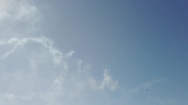 Gökyüzündeki bir uçak akrobasi figürlerini gösteriyor.