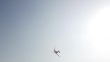 Gökyüzünde uçan büyük beyaz ve mavi yolcu uçağı. Mavi gökyüzü arka planına sahip siluet içinde yükselen bir uçak. Modern ulaşım ve havacılık. Yolcu jet uçağı gösteri uçuşunu gerçekleştiriyor..