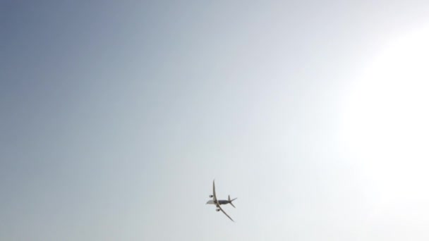 空を飛ぶ大きな乗客白と青の飛行機 青空を背景にシルエットで急上昇する飛行機 近代的な交通機関と航空 旅客機旅客機がデモンストレーション飛行を行う — ストック動画