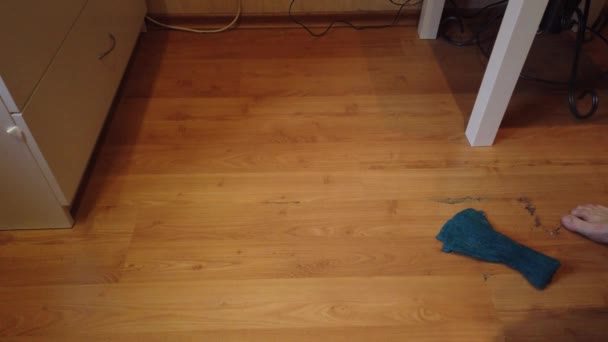 年轻人在家里洗地板 用特殊的布把人的污垢从木制地板上擦干净的衣服 — 图库视频影像
