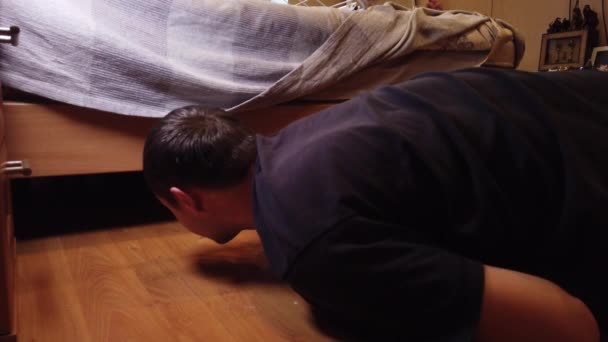 年轻人在家里洗地板 用特殊的布把人的污垢从木制地板上擦干净的衣服 — 图库视频影像