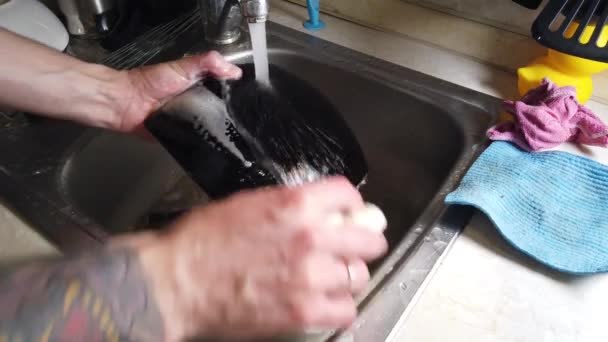 一个男人洗厨房的脏盘子的顶视图 — 图库视频影像