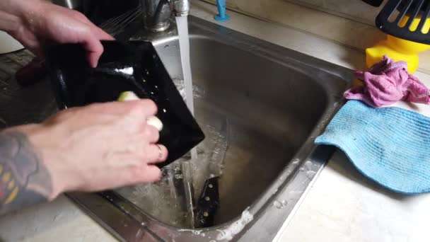 一个男人洗厨房的脏盘子的顶视图 — 图库视频影像