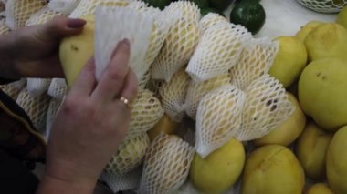 Marketin tezgahında tropikal Vietnam meyveleri satılıyor. Kız dükkanda egzotik meyveler seçiyor..