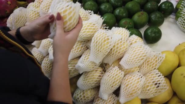 Vente fruits tropicaux du Vietnam sur le comptoir du marché. Fille choisit des fruits exotiques dans le magasin . — Video