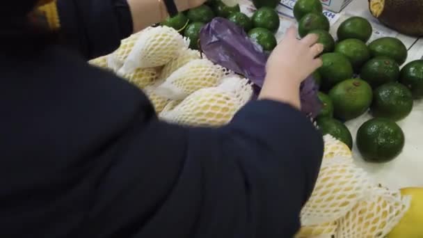 Verkauf tropischer vietnamesischer Früchte auf dem Tresen des Marktes. Mädchen wählt im Laden exotische Früchte. — Stockvideo