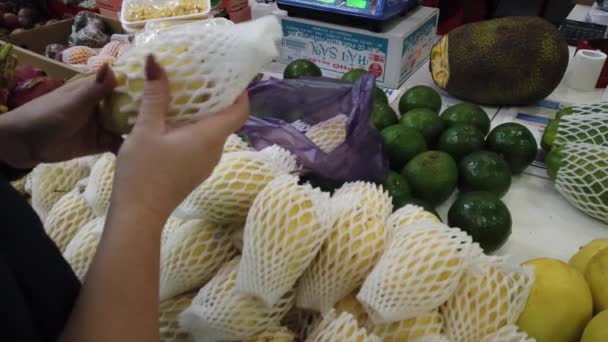 Venda de frutas tropicais do Vietnã no balcão do mercado. Menina escolhe frutas exóticas na loja . — Vídeo de Stock