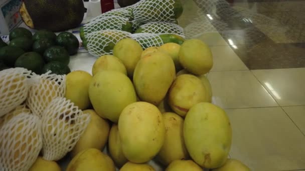 Sale tropical Vietnam fruits on the counter of the market. Girl chooses exotic fruits in the store. — Stock Video