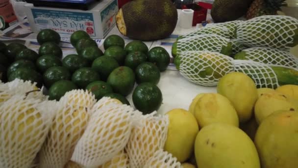 Verkoop tropisch Vietnam fruit op de toonbank van de markt. Meisje kiest exotisch fruit in de winkel. — Stockvideo