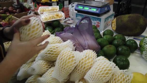 Venda de frutas tropicais do Vietnã no balcão do mercado. Menina escolhe frutas exóticas na loja . — Vídeo de Stock