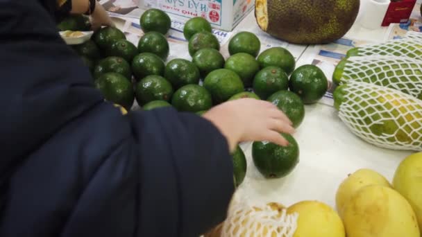 Vente fruits tropicaux du Vietnam sur le comptoir du marché. Fille choisit des fruits exotiques dans le magasin . — Video