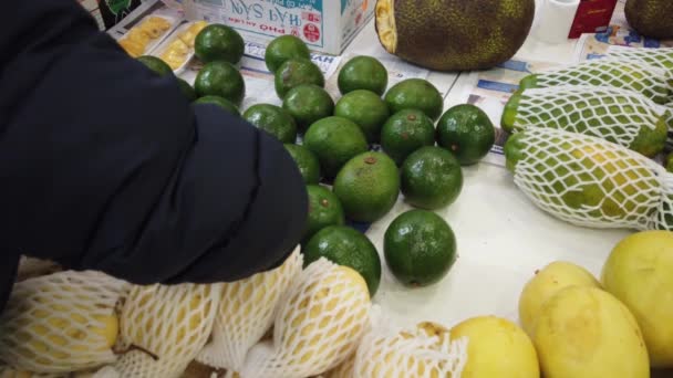 Försäljning tropiska Vietnam frukter på disken av marknaden. Flicka väljer exotiska frukter i butiken. — Stockvideo