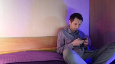 Evde bir adam telefonda oturuyor ve online bir kumarhanede oynuyor, kazanmanın verdiği duygular.