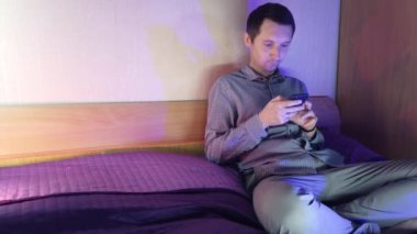 Evde bir adam telefonda oturuyor ve online bir kumarhanede oynuyor, kazanmanın verdiği duygular.