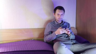 Evde bir adam telefonda oturuyor ve online bir kumarhanede oynuyor, kazanmanın verdiği duygular.