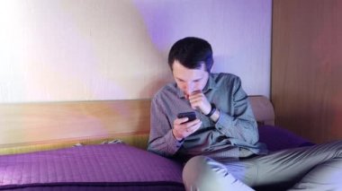 Evde bir adam telefonda oturuyor ve online bir kumarhanede oynuyor, kazanmanın verdiği duygular.