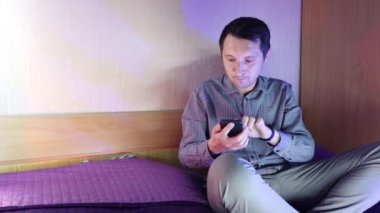 Evde bir adam telefonda oturuyor ve online bir kumarhanede oynuyor, kazanmanın verdiği duygular.