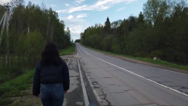 Dziewczyna Idzie Pustą Drogą Próbuje Złapać Autostopem — Wideo stockowe