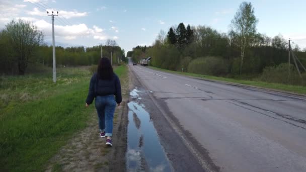 Dziewczyna Idzie Pustą Drogą Próbuje Złapać Autostopem — Wideo stockowe