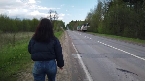 Dziewczyna Idzie Pustą Drogą Próbuje Złapać Autostopem — Wideo stockowe
