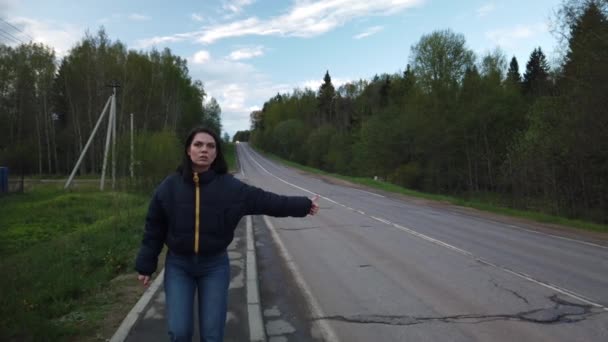Dziewczyna Idzie Pustą Drogą Próbuje Złapać Autostopem — Wideo stockowe