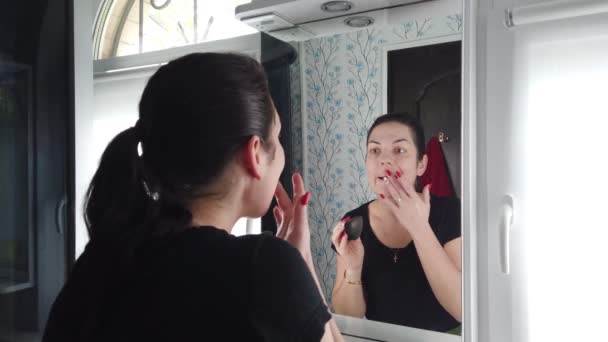 Όμορφη Μελαχρινή Γυναίκα Κάνει Μακιγιάζ Μπροστά Στον Καθρέφτη Στο Μπάνιο — Αρχείο Βίντεο
