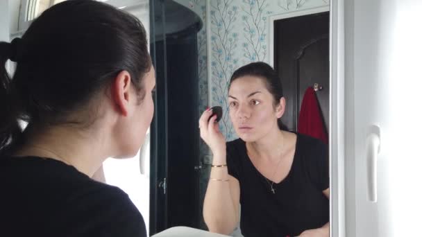 可愛いですブルネット女性あります化粧で鏡の前でバスルーム — ストック動画