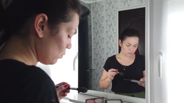 Όμορφη Μελαχρινή Γυναίκα Κάνει Μακιγιάζ Μπροστά Στον Καθρέφτη Στο Μπάνιο — Αρχείο Βίντεο