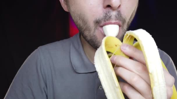 Een Man Met Een Baard Eet Een Banaan Een Half — Stockvideo