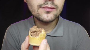 Kısa sakallı bir adam kapta dondurma yer, yakın plan.
