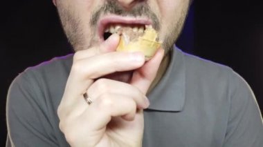 Kısa sakallı bir adam kapta dondurma yer, yakın plan.
