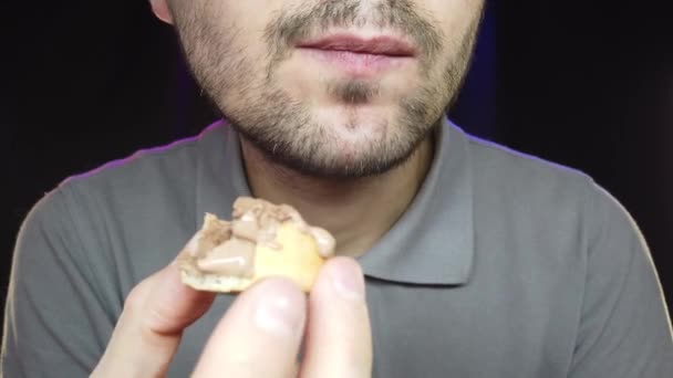 Un uomo con la barba corta mangia un gelato in una tazza, primo piano — Video Stock