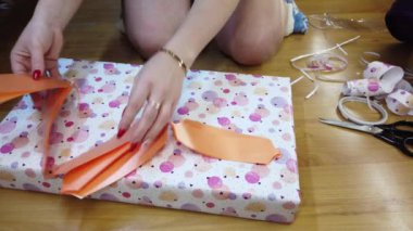 Kız ateşi çok renkli bir kağıda sarıp turuncu bir papyonla bağlıyor..