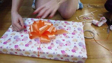 Kız ateşi çok renkli bir kağıda sarıp turuncu bir papyonla bağlıyor..