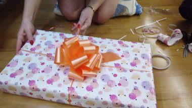 Kız ateşi çok renkli bir kağıda sarıp turuncu bir papyonla bağlıyor..