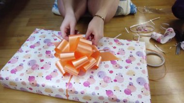 Kız ateşi çok renkli bir kağıda sarıp turuncu bir papyonla bağlıyor..