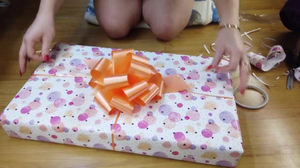 Girl Packs Fires Beautiful Multicolored Paper Ties Orange Bow — Stock Video