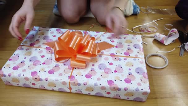 Girl Packs Fires Beautiful Multicolored Paper Ties Orange Bow — Stock Video