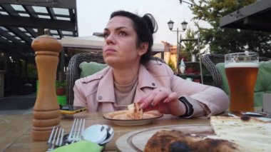 Kız İtalyan açık hava restoranının verandasında yemek yiyor.