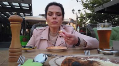 Kız İtalyan açık hava restoranının verandasında yemek yiyor.