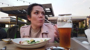 Kız İtalyan açık hava restoranının verandasında yemek yiyor.