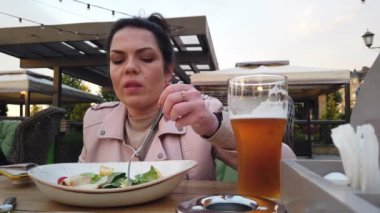 Kız İtalyan açık hava restoranının verandasında yemek yiyor.