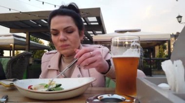 Kız İtalyan açık hava restoranının verandasında yemek yiyor.