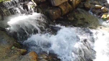 Küçük bir nehirde kaynayan bir şelale.