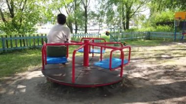 Yetişkin kız oyun parkının atlıkarıncasında dönüyor.